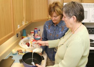 occupational therapist helping woman with cooking safely
