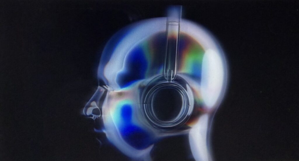 A glowing, translucent profile of a human head wearing over-ear headphones, rendered in shimmering blue, green, and rainbow tones against a black background.